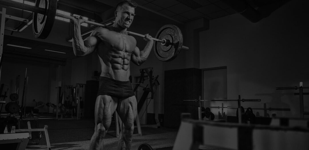 Athlete performing a heavy barbell squat in a dark gym to show Serious Supplements For Serious Performance